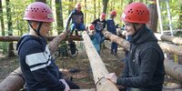 Jugendliche beim Bearbeiten der Stämme für das Baumhaus